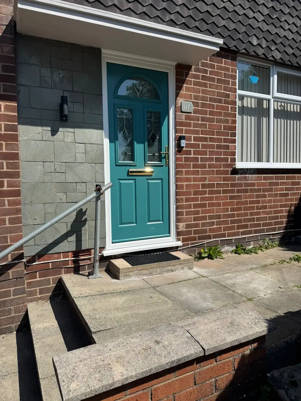 Teal composite front door with brass hardware